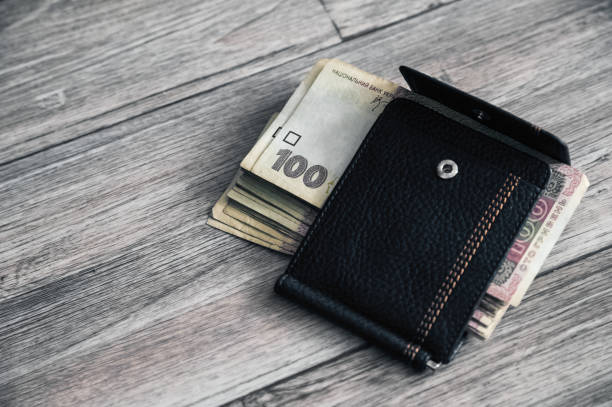 istock Stack of 100 Ukrainian hryvnias in black leather wallet. 1356387322