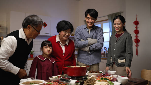 istock smiling asian father serving hot soup on the dining table and posing with folded arms, feeling proud of his cooking. preparing food for family on lunar new year’s eve 1356387449