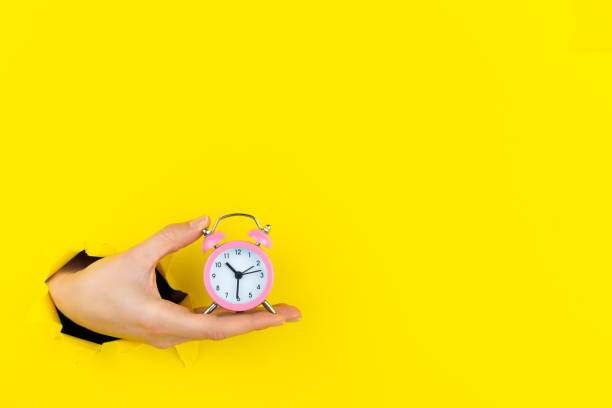 istock Hands hold ringing twin bell in torn hole 1356387684