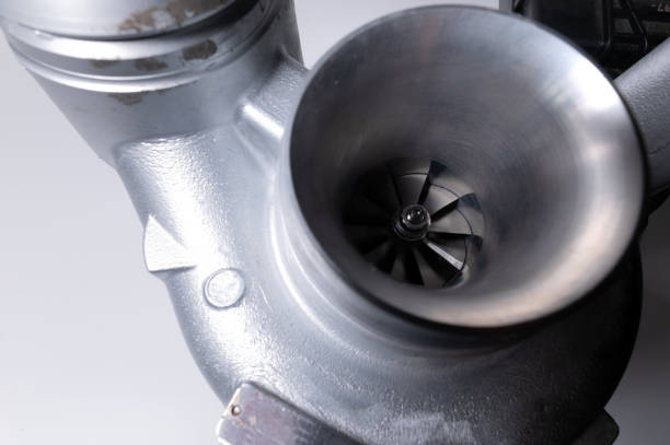 close-up of an auto part for an internal combustion engine. gas turbine. turbo supercharger new on a gray background. parts background - turbo diesel imagens e fotografias de stock
