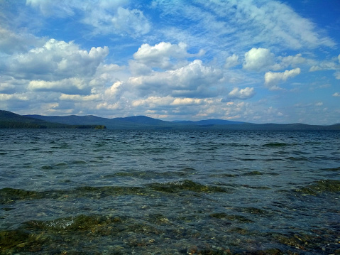 Christal water lake, clouds and stones. South Ural, lake Turgoyak