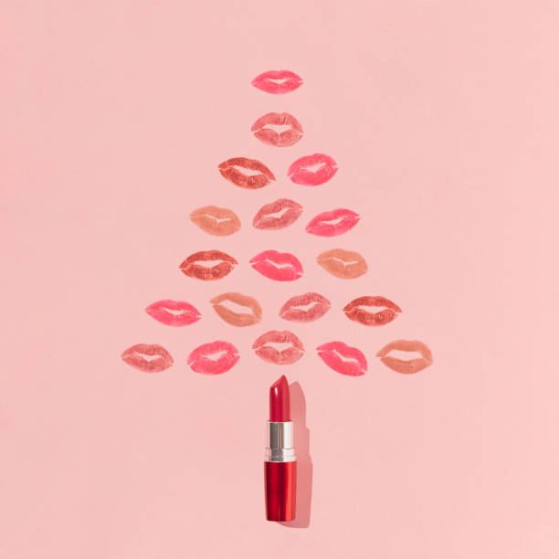 Christmas tree shape made of lipstick and colorful lip prints on bright pink background. Minimal New Year beauty concept. Creative make up or cosmetic aesthetic. Holiday kisses pattern. Christmas tree shape made of lipstick and colorful lip prints on bright pink background. Minimal New Year beauty concept. Creative make up or cosmetic aesthetic. Holiday kisses pattern. pink christmas tree stock pictures, royalty-free photos & images