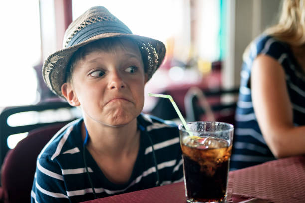 Little boy aged 7 doesn't like soda drink.\nNikon D850