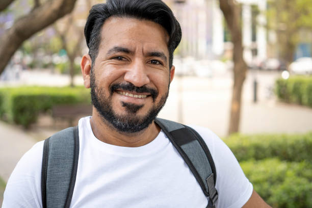 istock portrait of latin man with beard smiling at camera backpack 1356401447