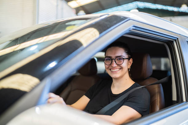 ritratto di giovane conducente della donna all'automobile - car insurance women driving foto e immagini stock