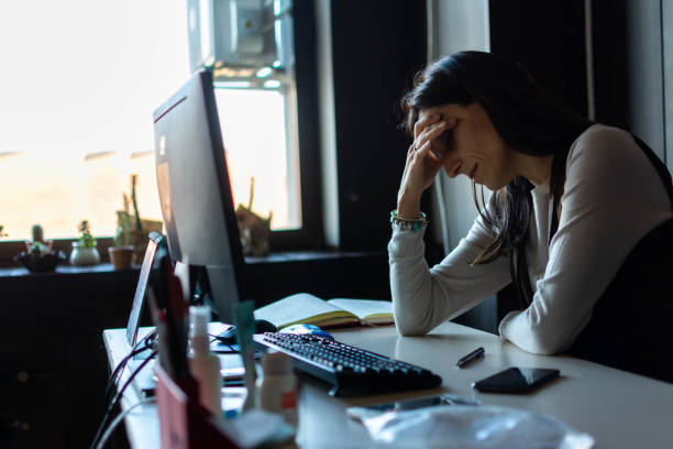 istock Female entrepreneur with headache sitting at desk 1356402444