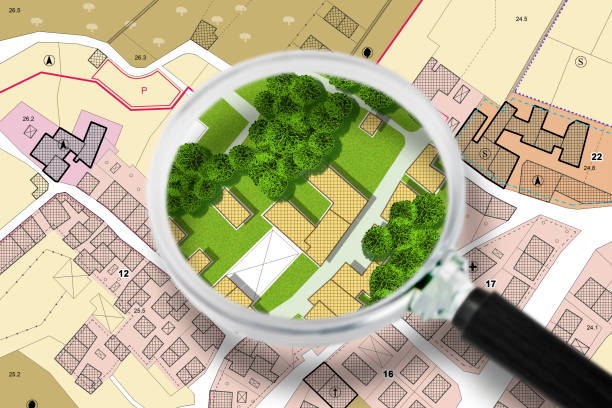 Searching new home - concept with an imaginary General Urban Plan with buildings, roads and magnifying glass - NOTE: the map is totally invented and does not represent any real place stock photo