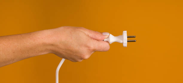istock white electrical cable with a plug in hand on a yellow background 1356404144
