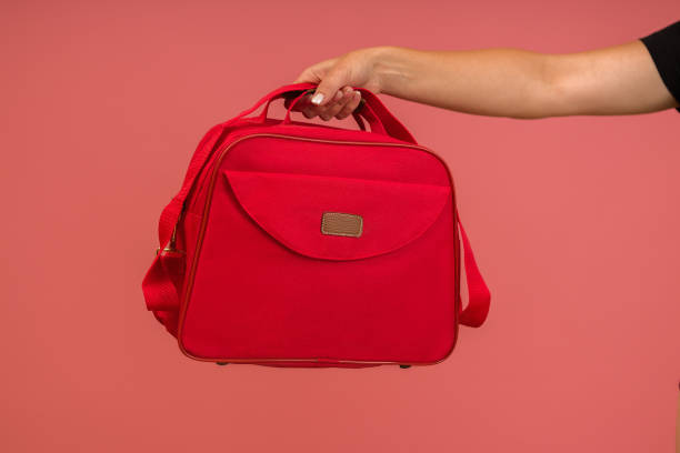istock red cloth women bag in hand on pink background 1356404156