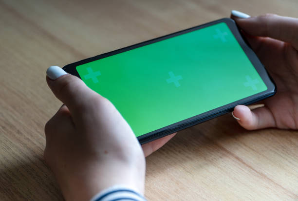 istock The girl's hands are using a mobile phone with a chroma key. 1356405525