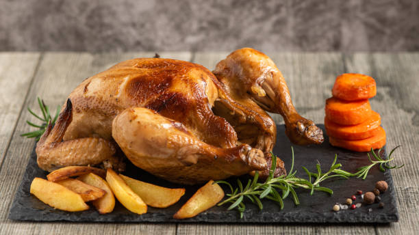 istock Whole roasted chicken with vegetables. Close up 1356405565