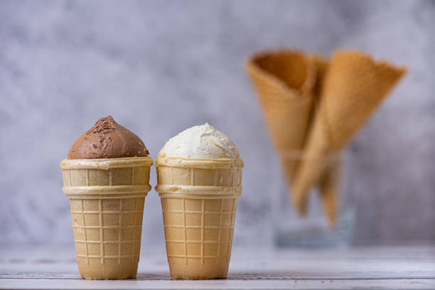 istock Vanilla and chocolate ice cream. and waffle cones on light background. Side view 1356405774