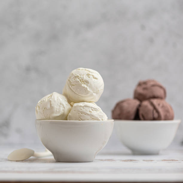 Bowl of vanilla and chocolate ice cream. on light background. Side view stock photo