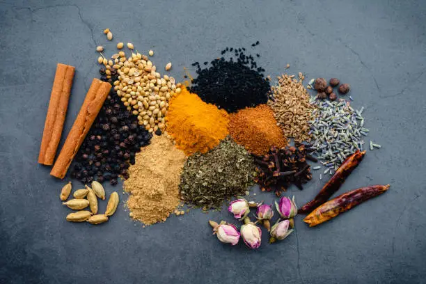 Ingredients for a Moroccan spice mix made of dried herbs, spices, and flowers