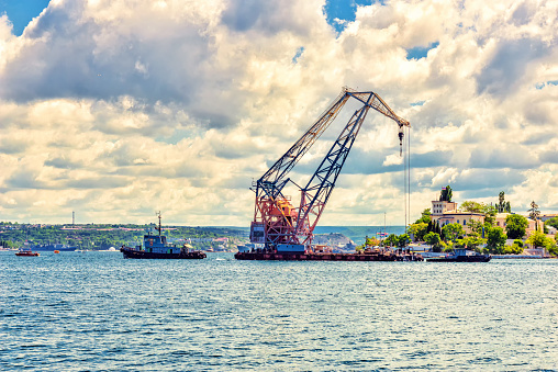 In Yuzhnaya Bay in the city of Sevastopol, a large floating port crane is being moved with the help of tugs