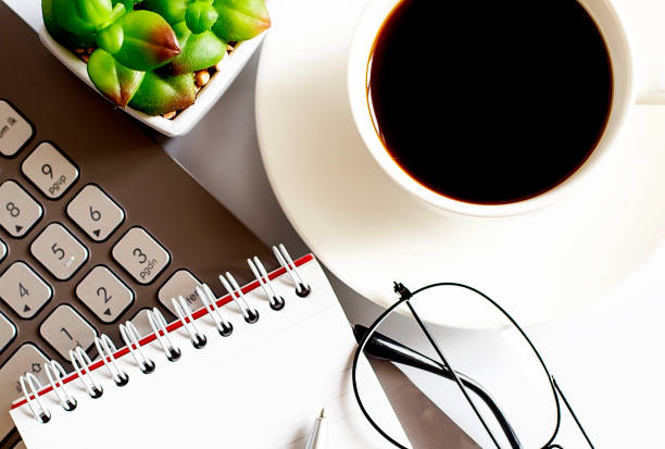 istock Office supplies, devices, coffee cup ,laptop and glasses on white table 1356408790