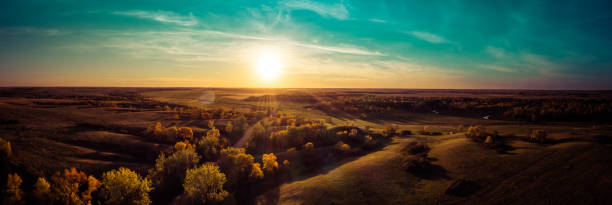 Aerial panorama of a sunset over the gentle rolling hills of the Great Plains with trees in their autumn colors Aerial panorama of a sunset over the gentle rolling hills of the Great Plains with trees in their autumn colors in North Dakota. north dakota stock pictures, royalty-free photos & images