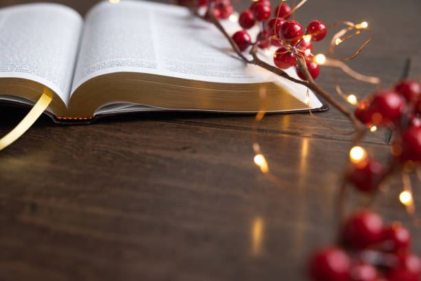 istock Open bible with red berries and Christmas lights 1356409194