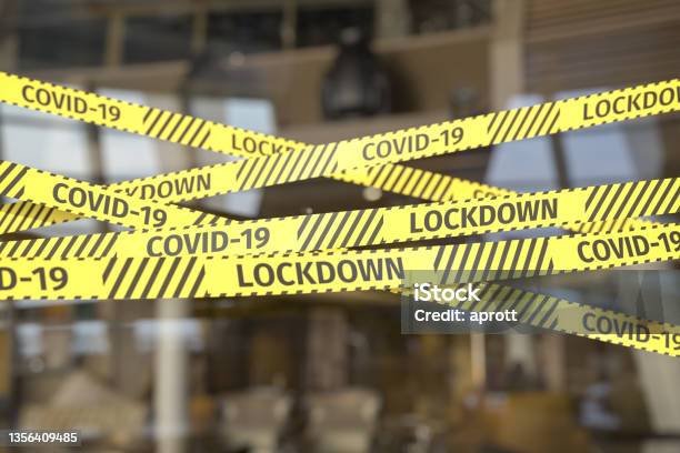 Barrier Tape Restricting Access To A Restaurant Or Shop Warning Text Covid19 And Lockdonw On The Tape Stock Photo - Download Image Now