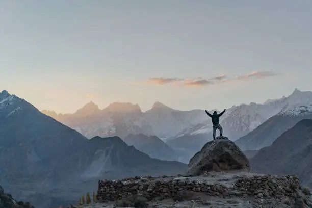 Unrecognizable man   standing on rock and looking at river in Himalayas