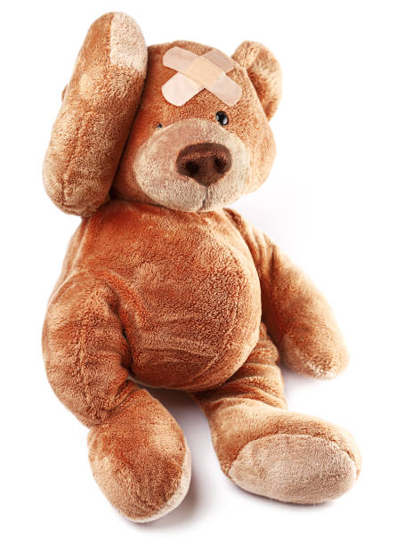 istock Teddy bear with bandage on the forehead isolated on white background. Child role modeling of doctor. 1356410459