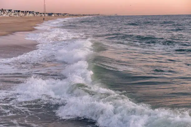 Manasquan, New Jersey, USA - Ocean waves breaking onto the beach at Sunrise as the tide comes in