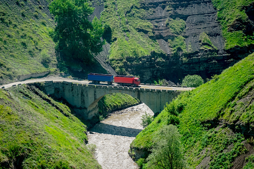 Truck rides over the bridge over the mountain river