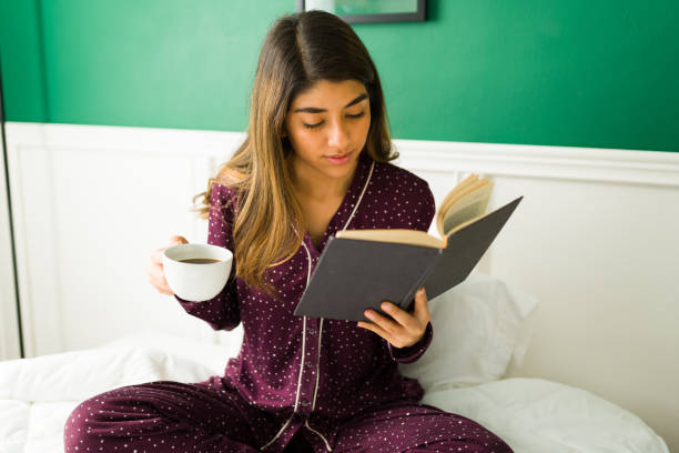 istock Beautiful woman reading a book 1356414353
