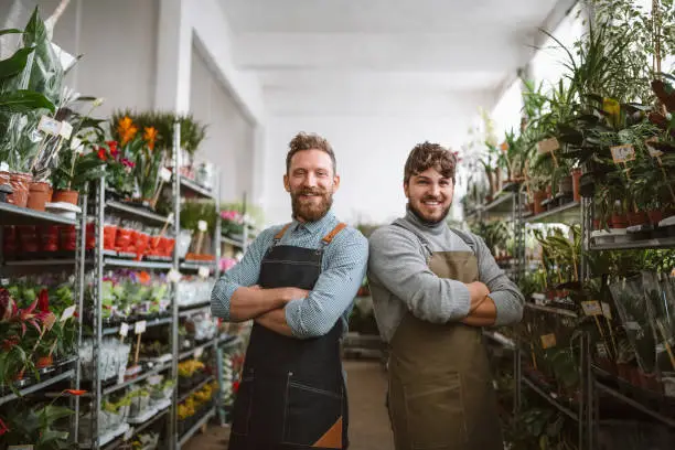 Portrait of two male florists in floral gardening warehouse