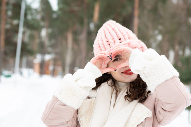 istock Cheerful lady making heart shape from her fingers 1356414697