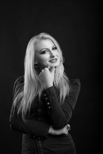 pretty blond lady with perfect makeup and long straight hair wears blouse, posing at studio. black and white sho - studio sho imagens e fotografias de stock