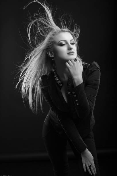 istock Magnificent blond woman with long fluttering hair posing at studio 1356415124