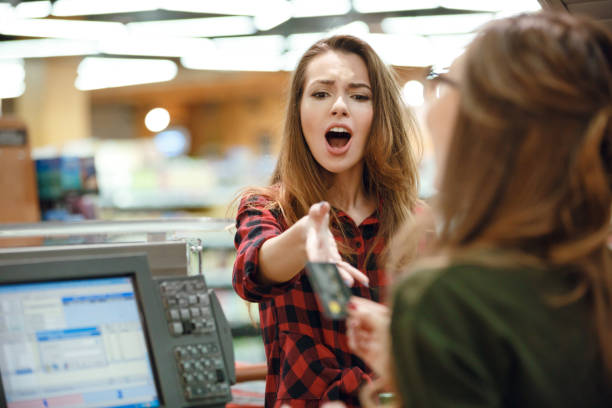 istock Confused young lady looking at credit card. 1356416768