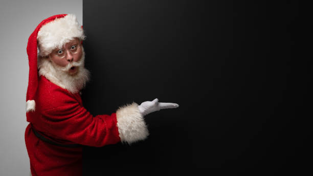 istock Santa Claus pointing black billboard 1356418867