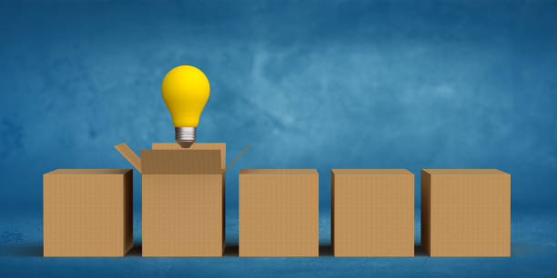 istock Side view on retro style light bulb out of box on blue blank background 1356421411