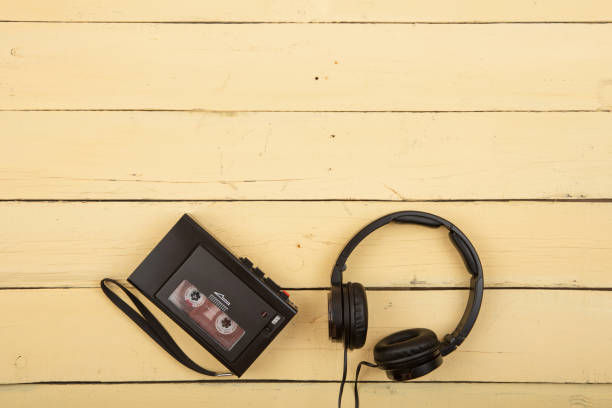 istock Retro cassette player with headphones on yellow background, flat top view 1356421717