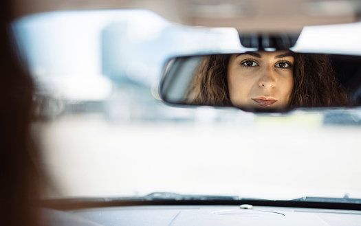 Sad woman car mirror reflection