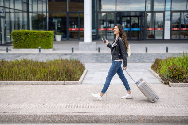 istock Beautiful woman rolling suitcase 1356421877