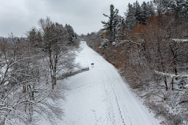 Man in a black jacket riding a mountain on a plastic sled in winter, Russia, Bugotak Hills