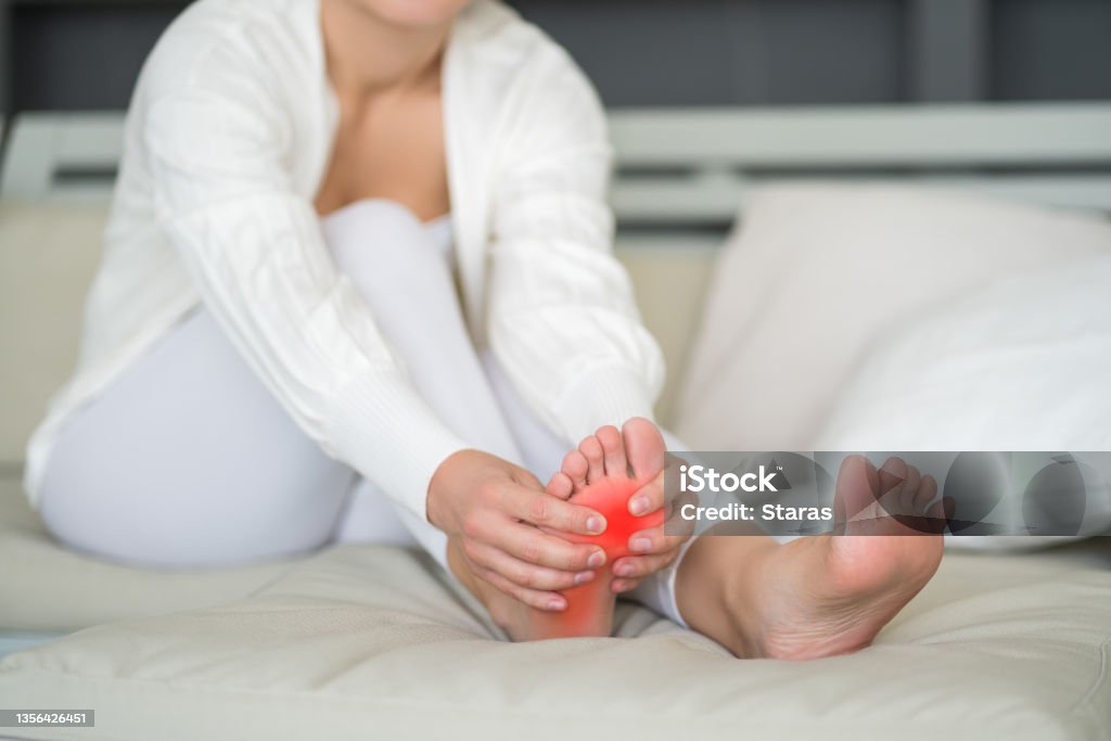 Joint diseases, hallux valgus, plantar fasciitis, heel spur, woman's leg hurts, pain in the foot, massage of female feet at home Joint diseases, hallux valgus, plantar fasciitis, heel spur, woman's leg hurts, pain in the foot, massage of female feet at home, health problems concept Plantar Fasciitis Stock Photo