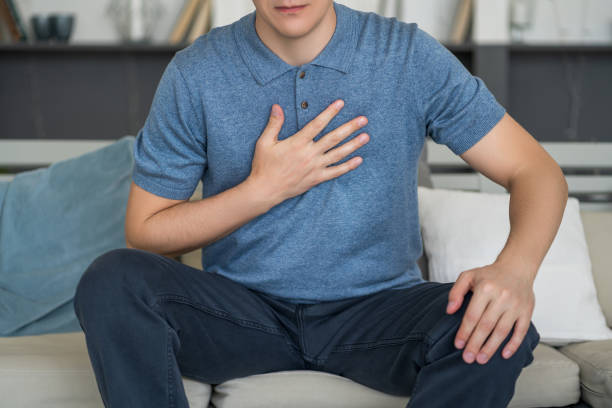 dolor en el pecho y tos, hombre con dolor pulmonar en casa - gasping fotografías e imágenes de stock