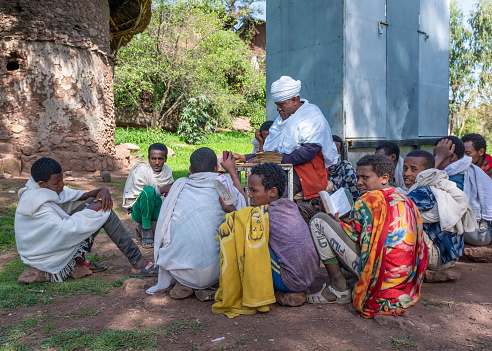 Lalibela, Ethiopia - May 21, 2021: Teacher and pupils, taken outside in a sunny afternoon