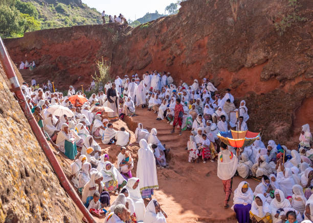 A group of parishioners and pilgrims, Lalibela, Ethiopia Lalibela, Ethiopia - May 23, 2021: A large group of parishioners and pilgrims, men and women, wearing white clothing, turbans and veils ethiopian orthodox church stock pictures, royalty-free photos & images