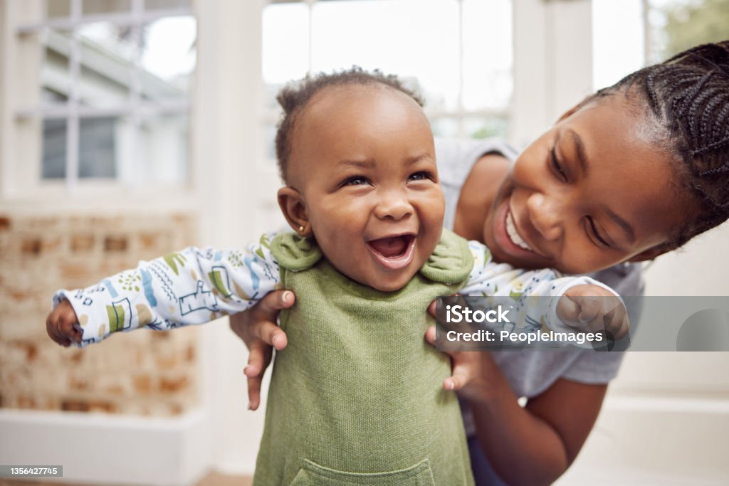 Shot of a young woman bonding with her baby at home Look! I can stand Baby - Human Age Stock Photo
