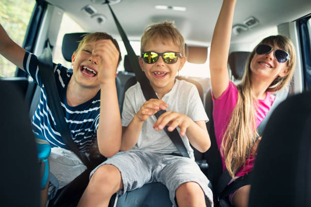 Brothers and sisters enjoying travelling by car stock photo