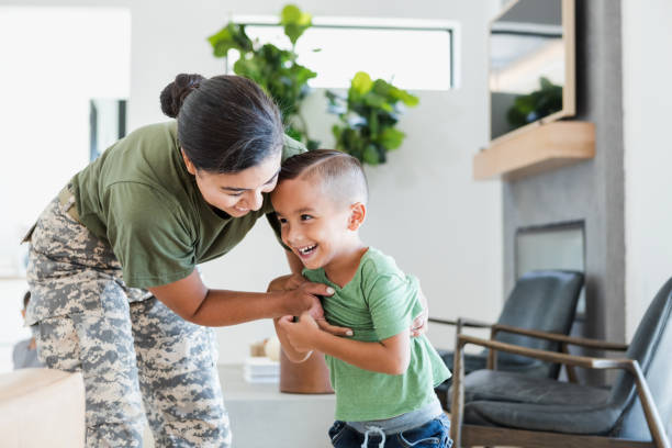 istock Female soldier smiles while playing with young son 1356429509