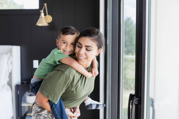 istock Cheerful boy rides piggyback on mom's back 1356430159