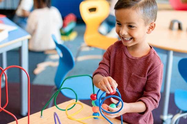 istock Young boy works independently on bead puzzle 1356433442