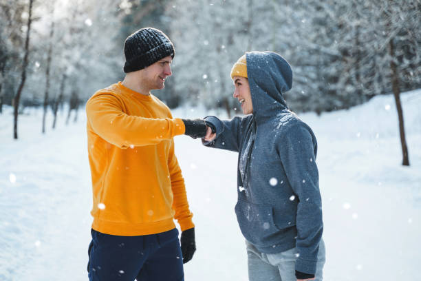 istock Two joggers greeting each other with a fist bump gesture during winter workout 1356437185
