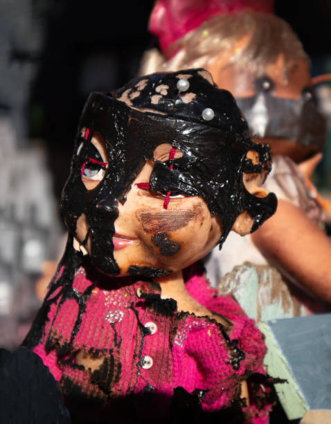 istock Creepy baby doll with black tar over face. 1356437188